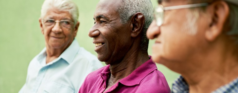 Image of a group of ethnically diverse, elderly men, smiling and talking to each other